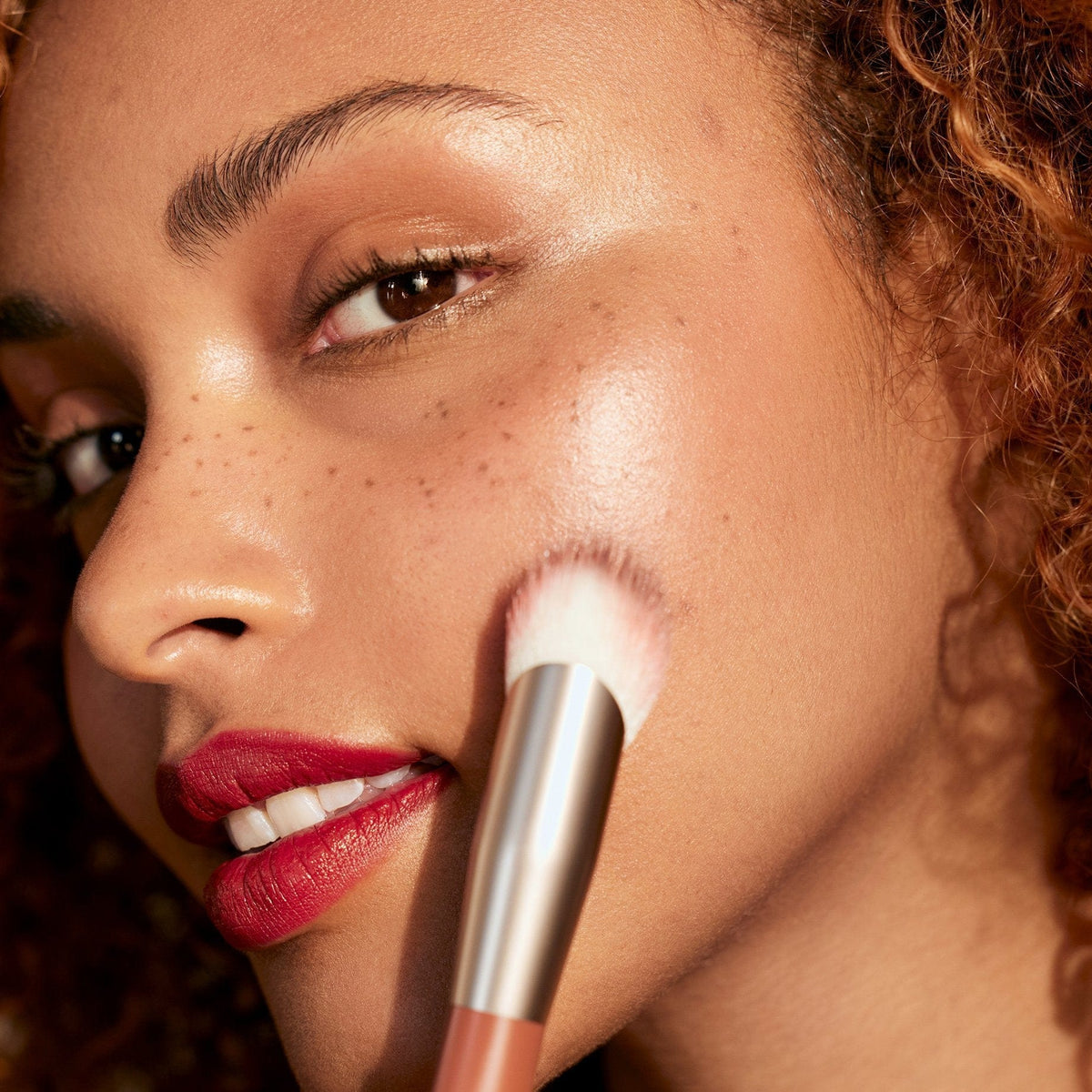 Model using the Rose Inc Blush Brush on cheek